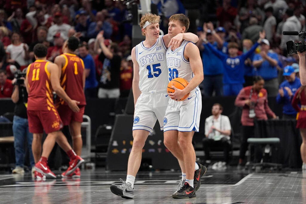 Brigham Young's Richie Saunders (15) and Dallin Hall (30) celebrate after defeating Iowa State during an NCAA college basketball game in the quarterfinal round of the Big 12 Conference tournament, Thursday, March 13, 2025, in Kansas City, Mo. (AP Photo/Charlie Riedel)