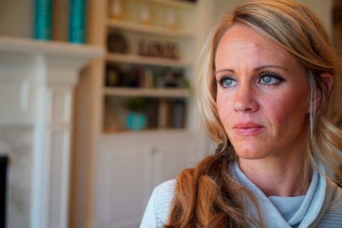 In this March 27, 2019, photo, Kacey Ruegsegger Johnson poses for a portrait at her home in Cary, N.C. Ruegsegger Johnson, now a mother of four, survived a shotgun blast during the 1999 shootings at Colorado's Columbine High School that left 12 students, one teacher, and both gunmen dead. The emotional toll of the shooting, joined by fears about their own kids’ safety, spikes each time yet another shooter enters another school. (AP Photo/Allen G. Breed)