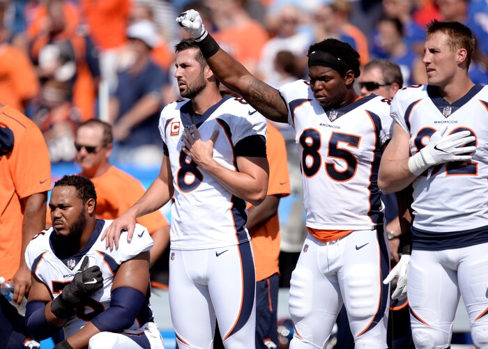 Denver Broncos tight end Virgil Green (85) gestures as teammate Max Garcia, left, takes a knee during the paying of the national anthem prior to an NFL football game against the Buffalo Bills, Sunday, Sept. 24, 2017, in Orchard Park, N.Y. (AP Photo/Adrian Kraus)