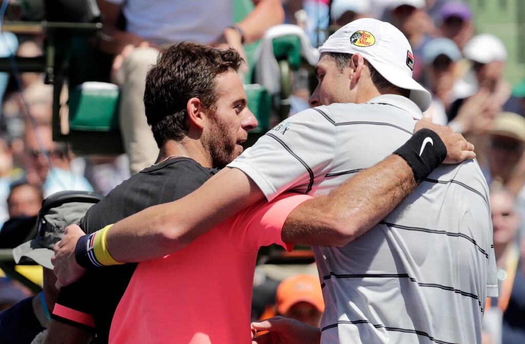 John Isner, right, and Juan Martin del Potro, of Argentina, left, embrace at the net after their semifinal match at the Miami Open tennis tournament, Friday, March 30, 2018, in Key Biscayne, Fla. Isner won 6-1, 7-6 (2). (AP Photo/Lynne Sladky)
