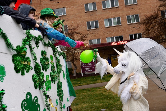 (Scott Sommerdorf | The Salt Lake Tribune) Children get a green balloon from a passing unicorn before the 40th annual Salt Lake City St. Patrick's Day Parade on Saturday, March 17, 2018.