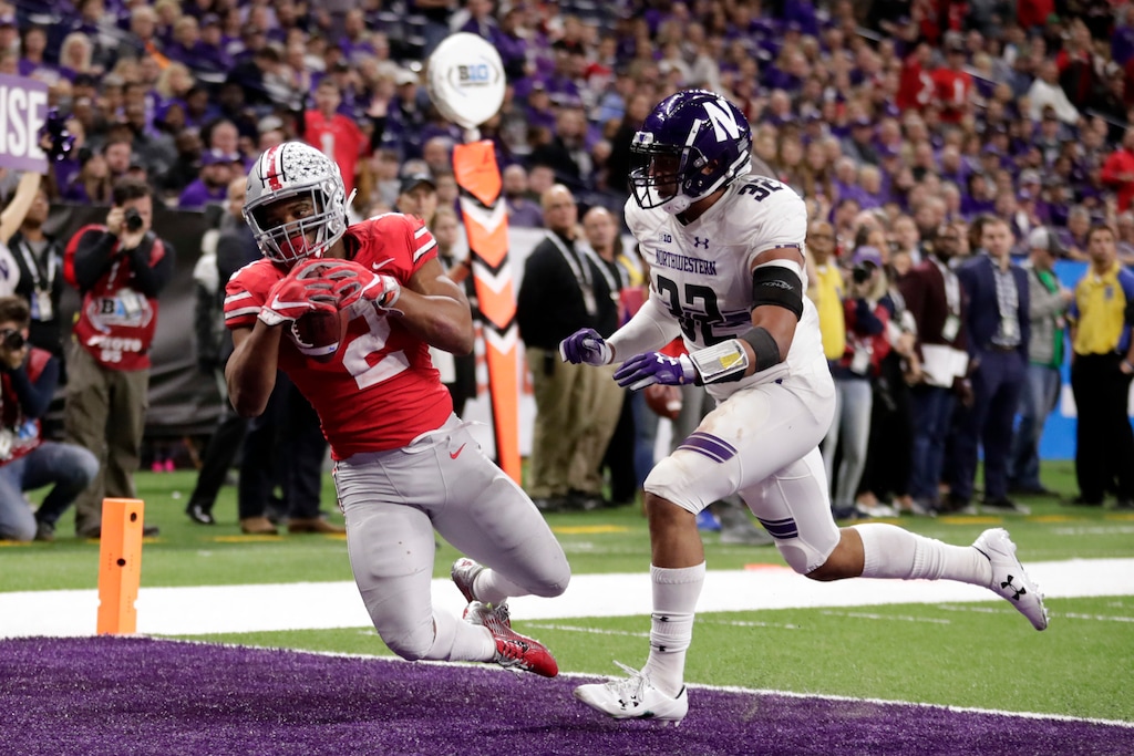 (AP Photo/Michael Conroy) Ohio State running back J.K. Dobbins (2) catches a touchdown pass as Northwestern's Nate Hall (32) defends during the second half of the Big Ten championship NCAA college football game, Saturday, Dec. 1, 2018, in Indianapolis. Ohio State won 45-24.