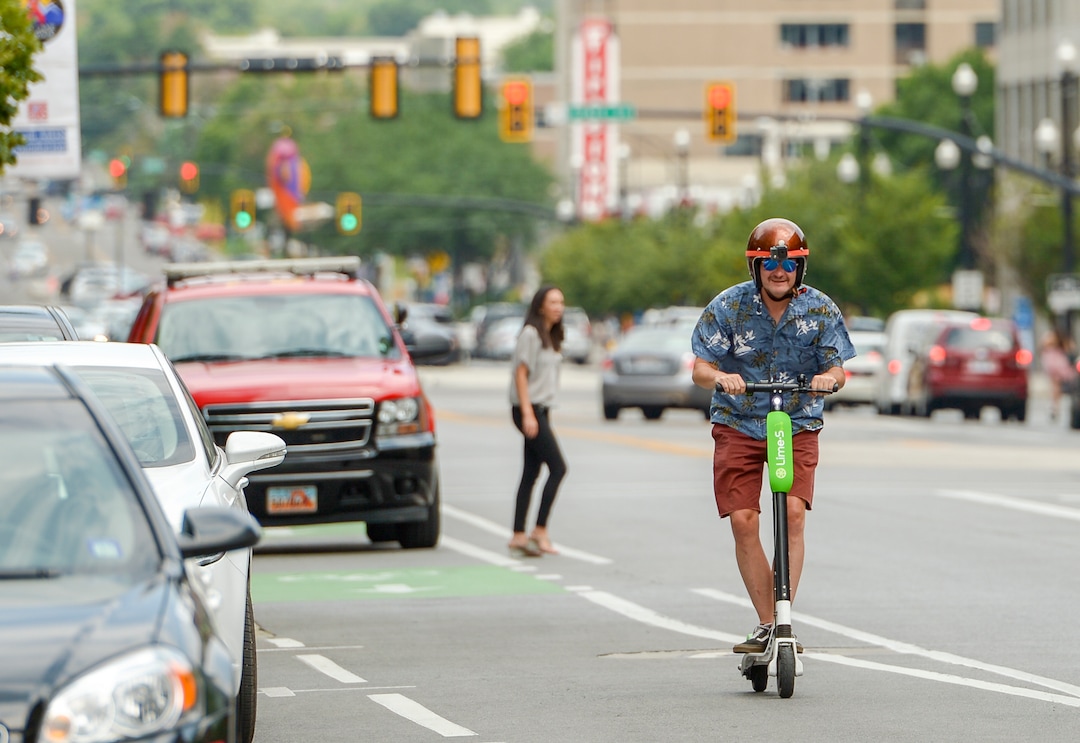 Leah Hogsten  |  The Salt Lake Tribune  Salt Lake Tribune columnist Robert Gehrke rides a Lime dockless e-scooter from the Salt Lake City Library to The Salt Lake Tribune building, Thursday, August 2, 2018.  · 