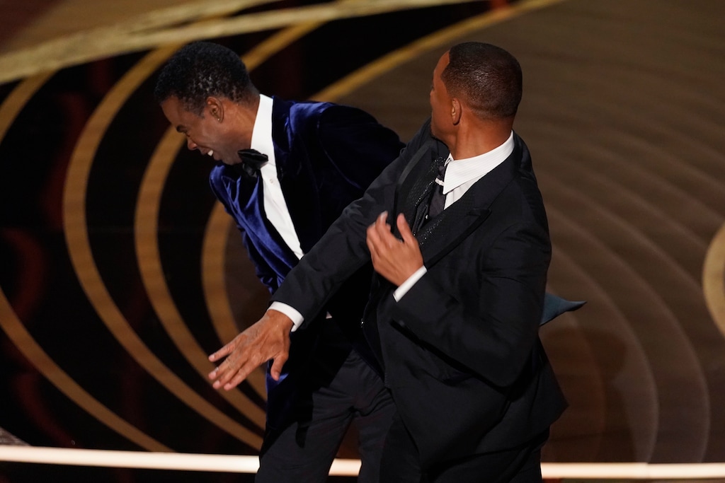 (Chris Pizzello | AP) Will Smith, right, hits presenter Chris Rock on stage while presenting the award for best documentary feature at the Oscars on Sunday, March 27, 2022, at the Dolby Theatre in Los Angeles.