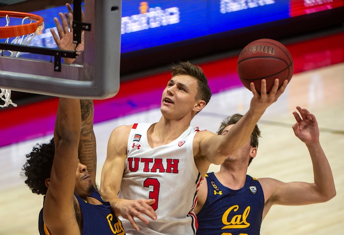 (Rick Egan | The Salt Lake Tribune) Utah Utes guard Pelle Larsson (3) scores as California Golden Bears guard Matt Bradley (20) and California Golden Bears guard Ryan Betley (00) defend, in PAC12 Basketball action between the the Utah Utes and the California Golden Bears, on Wednesday, Jan. 16, 2021.