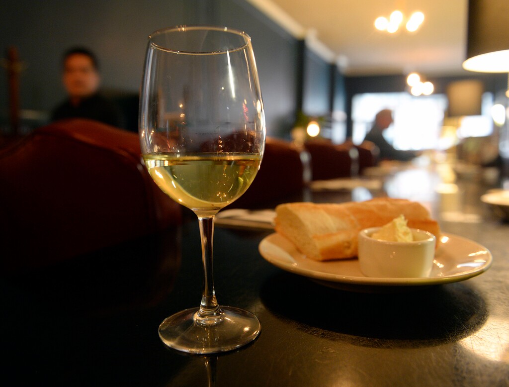 (Al Hartmann | Tribune file photo) A glass of wine and plate of bread at a Salt Lake City restaurant in 2017. Utah's liquor commission warned restaurants at an April 27, 2023, meeting that it will be stringent with applications because of a scarcity of restaurant licenses, even with an influx of 30 extra licenses approved by the Utah Legislature that will become available in May 2023.