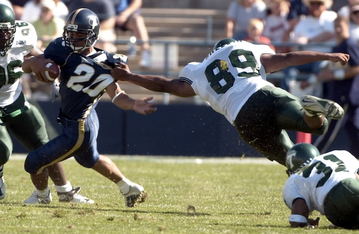(Rick Egan  |  Tribune File Photo)  Tulane defensive lineman Roxie Shelvin gets a hand on the jersey of  BYU's Reno Mahe in the BCA Classic at Lavell Edwards Stadium in Provo on August 25, 2001.