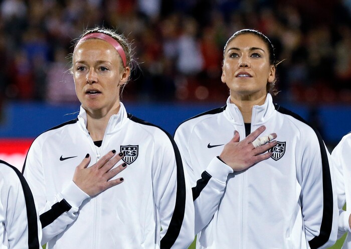 United States' Becky Sauerbrunn, left, and Hope Solo, right, stand during the playing of the national anthem before the team's CONCACAF Olympic qualifying tournament soccer match against Costa Rica on Wednesday, Feb. 10, 2016, in Frisco, Texas. (AP Photo/Tony Gutierrez)
