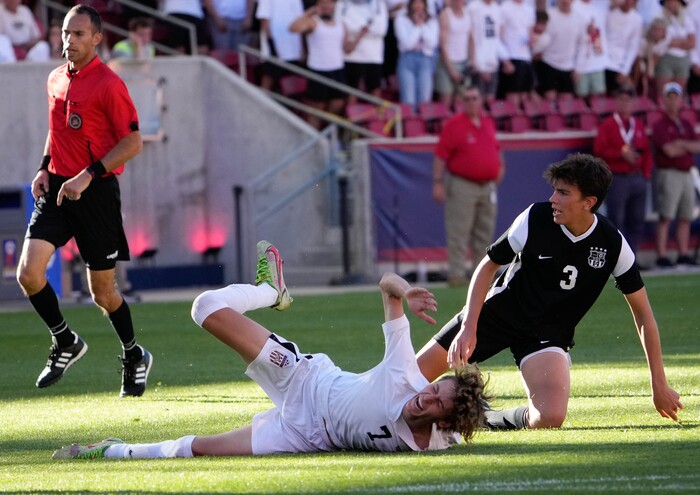 (Francisco Kjolseth | The Salt Lake Tribune) Herriman's Trevor Walk (7) goes down over Davis's Luke Bitner (3) during their 6A State Soccer Championship title game at Rio Tinto Stadium, Wednesday, May 25, 2022. Herriman defeated Davis 1-0 with two seconds left on the clock.