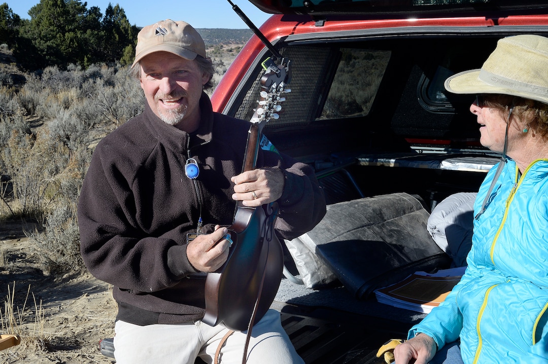 (Scott Sommerdorf   |  The Salt Lake Tribune)   BLM Paleontologist Alan Titus smiles as he plays Jeanette Bonnell's mandolin prior to the transport of the skeleton of a T-Rex from near Tropic, Utah, Sunday, October 15, 2017. 