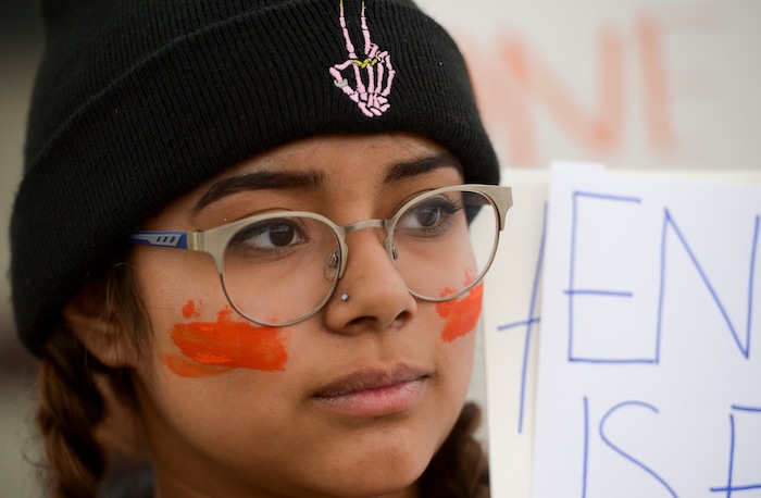 (Leah Hogsten  |  The Salt Lake Tribune) East High School senior, Julie Allbor painted her cheeks orange to say "#enough."Exactly one month after 17 people were killed at Marjory Stoneman Douglas High School in Parkland, survivors of the massacre joined tens of thousands of students across the United States by walking out of school,  Wednesday, March 14, 2018. 