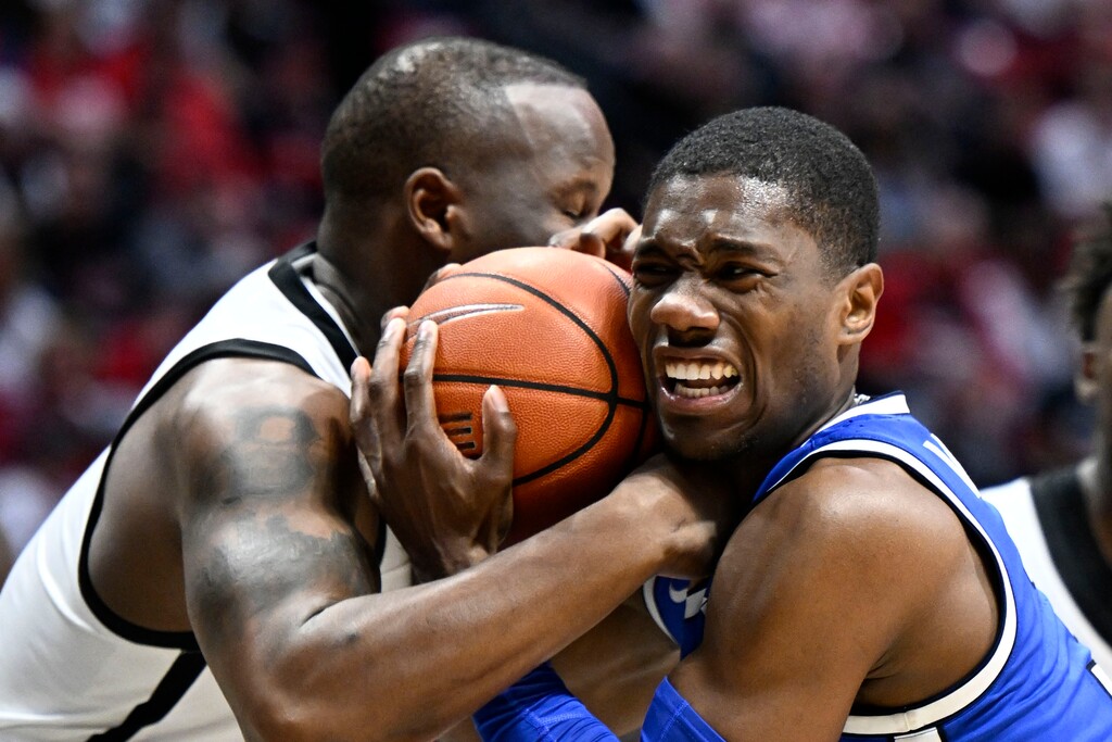 San Diego State guard Matt Bradley, left, wrestles for the ball with BYU guard Rudi Williams during the second half of an NCAA college basketball game Friday, Nov. 11, 2022, in San Diego. (AP Photo/Denis Poroy)
