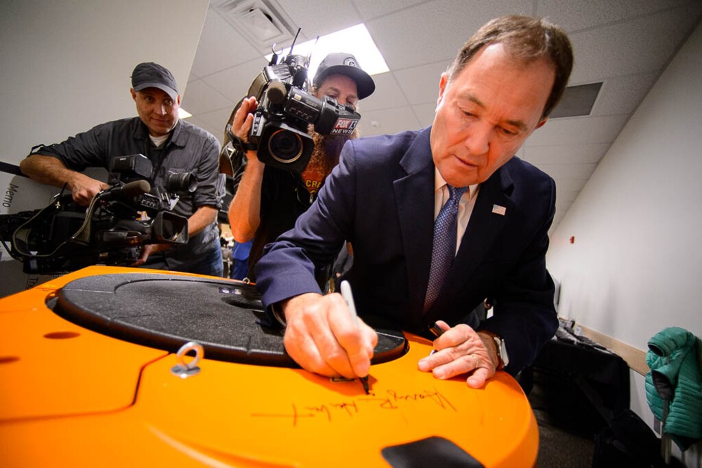 (Trent Nelson  |  The Salt Lake Tribune) Utah Governor Gary Herbert puts his signature on a robot at Amazon's fulfillment center in Salt Lake City on Wednesday April 17, 2019.