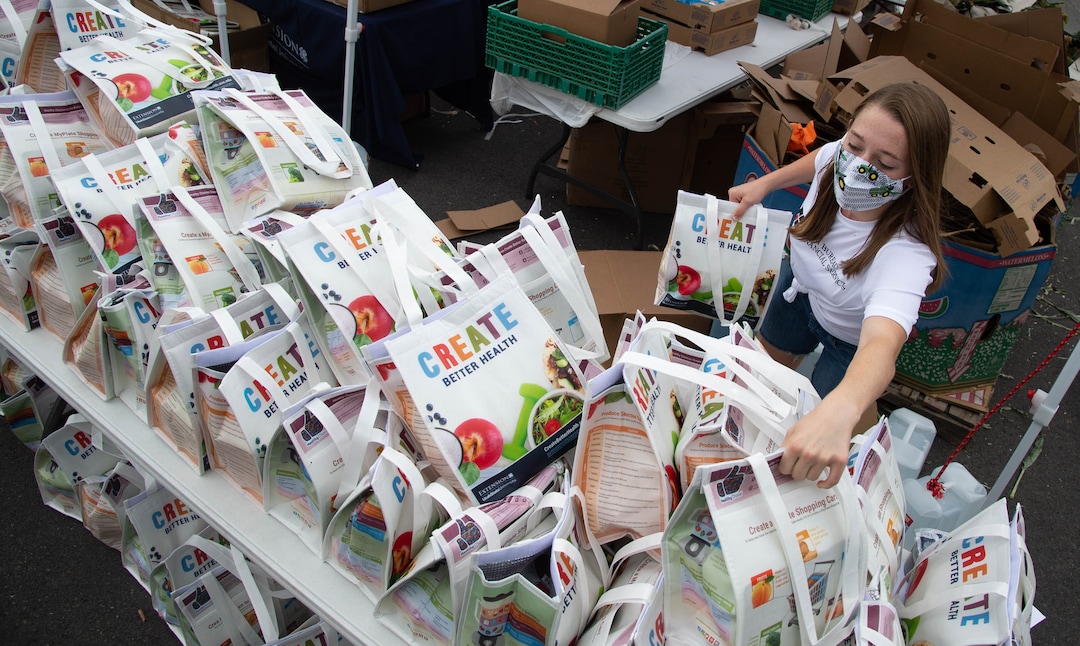 (Francisco Kjolseth  |  The Salt Lake Tribune) Paige Smith lends a helping hand as the third “Miracle Project” for the nonprofit foundation which raises money to purchase food produced by Utah farmers and then gives to residents in need, takes place at the Utah State Fairpark in Salt Lake City on Monday, July 27, 2020. The food donation from the Utah Farm Bureau’s “Farmers Feeding Utah” program provided food for 600 individuals and families who have recently become unemployed due to the coronavirus.
