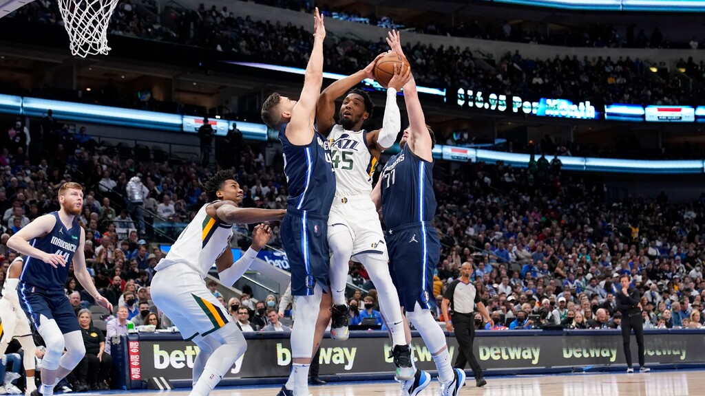 Utah Jazz guard Donovan Mitchell (45) attempts to pass the ball between Dallas Mavericks' Maxi Kleber, center left, and Luka Doncic (77) in the first half of an NBA basketball game in Dallas, Monday, March, 7, 2022. (AP Photo/Tony Gutierrez)