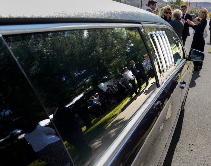 (Steve Griffin  |  The Salt Lake Tribune)  People gathered around the casket are reflected in a car's window following graveside services for Elder Robert D Hales at the Bountiful City Cemetery in Bountiful Friday October 6, 2017.
