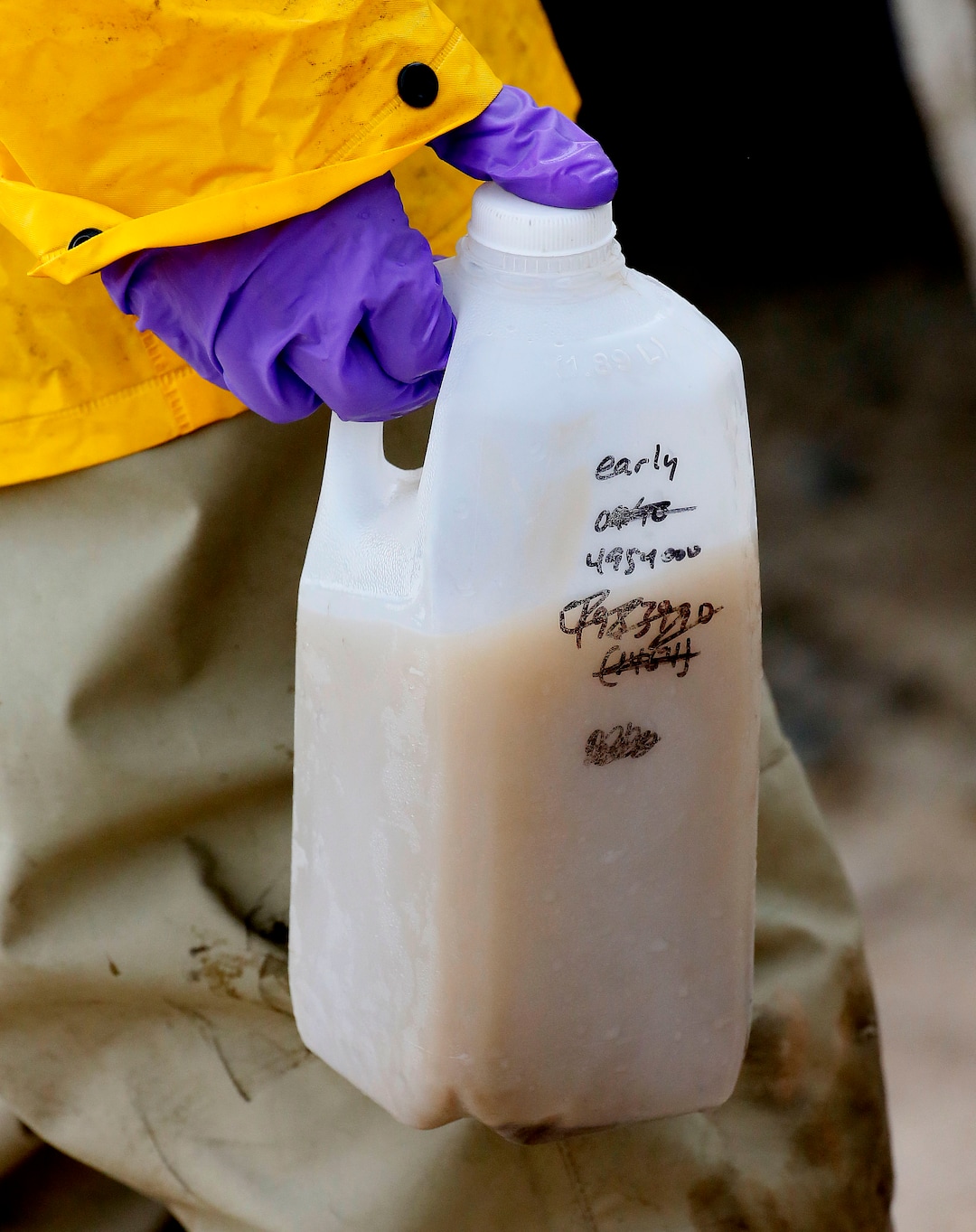 Hydrologic Technician Ryan Parker carries a water sample from the San Juan River, Tuesday, Aug. 11, 2015, in Montezuma Creek, Utah. A spill containing lead and arsenic from the abandoned Gold King Mine in Silverton, Colo., leaked into the Animas River, which flows into the San Juan River in Southern Utah, on Aug. 5. The spill was caused by a mining and safety team working for the EPA.  (AP Photo/Matt York) 