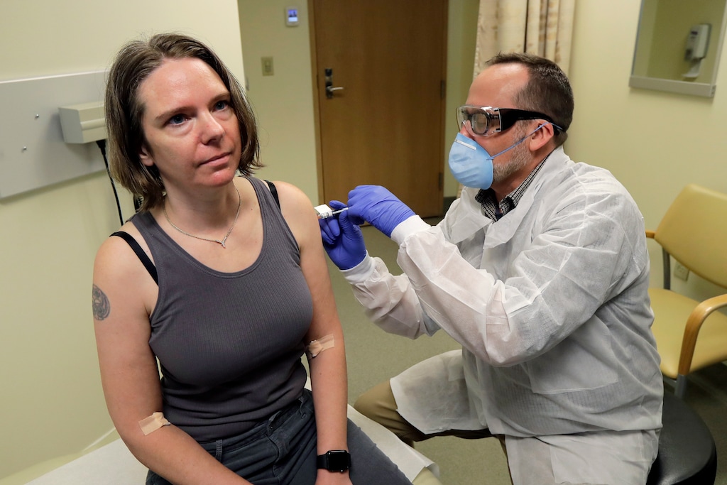 (Ted S. Warren | AP file photo) A pharmacist gives Jennifer Haller, left, the first shot in the first-stage safety study clinical trial of a potential vaccine for COVID-19, the disease caused by the new coronavirus, at the Kaiser Permanente Washington Health Research Institute in Seattle on March 16, 2020. The vaccine by Cambridge, Massachusetts-based Moderna Inc., generated antibodies similar to those seen in people who have recovered from COVID-19 in a study volunteers who were given either a low or medium dose.