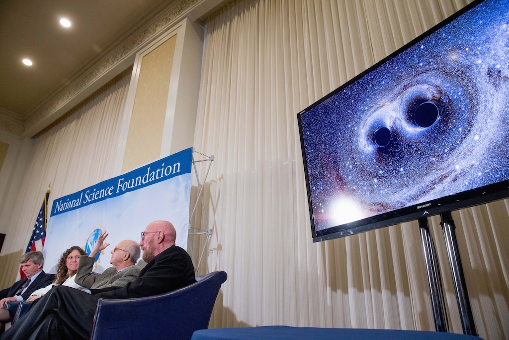From left, Interferometer Gravitational-Wave Observatory (LIGO) Exectutive Director David Reitze, LIGO Scientific Collaboration Spokesperson Gabriela Gonzalez, and Laser Interferometer Gravitational-Wave Observatory (LIGO) Co-Founders Rainer Weiss and Kip Thorne, appear next to a visual of gravitational waves from two converging black holes during a news conference at the National Press Club in Washington, Thursday, Feb. 11, 2016, to announce that scientists they have finally detected gravitational waves, the ripples in the fabric of space-time that Einstein predicted a century ago. The announcement has electrified the world of astronomy, and some have likened the breakthrough to the moment Galileo took up a telescope to look at the planets. (AP Photo/Andrew Harnik)