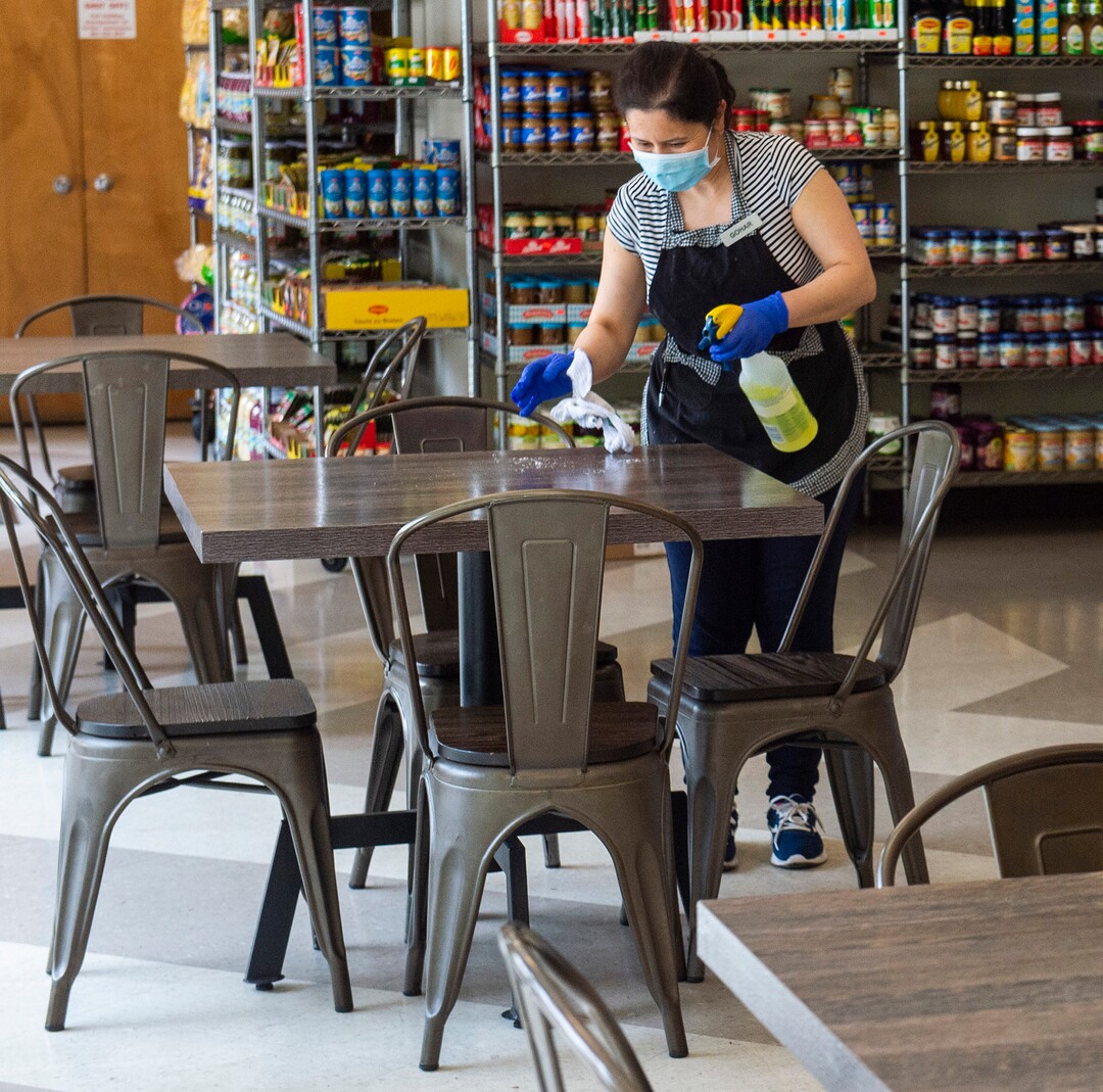 (Rick Egan  |  The Salt Lake Tribune)    Gohar Khachajryan wipes down the tables with disinfectant between customers, at Siegfried's Delicatessen, which is now open for indoor dining, Friday May 1, 2020