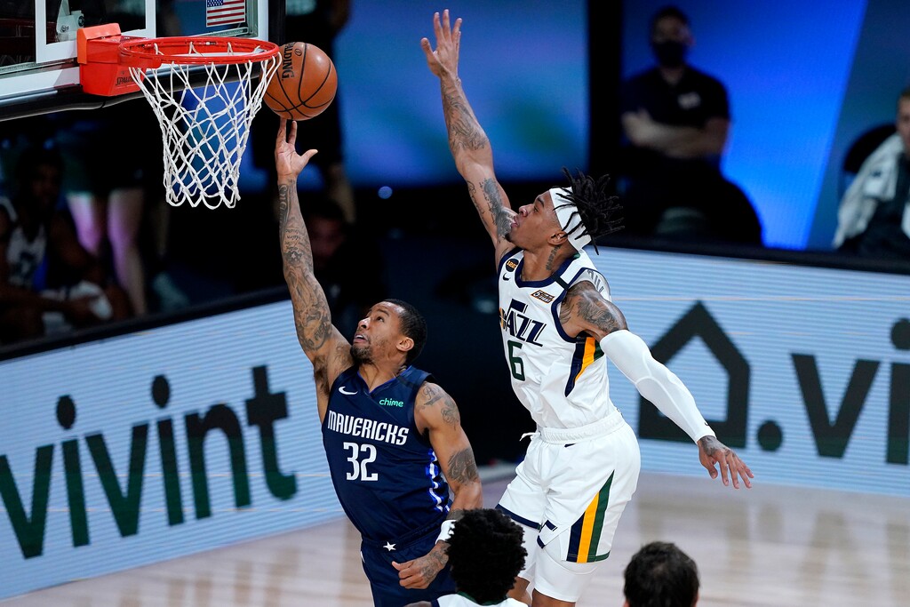 Dallas Mavericks Trey Burke (32) shoots under Utah Jazz's Rayjon Tucker (6) during the second half of an NBA basketball game Monday, Aug. 10, 2020, in Lake Buena Vista, Fla. (AP Photo/Ashley Landis, Pool)