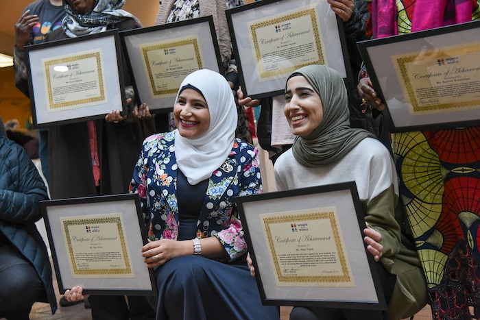 (Francisco Kjolseth  |  The Salt Lake Tribune)  Saja Abbas, left, of Iraq, and Sahar Najim of Kuwait proudly hold their certificates of achievement alongside 23 other refugee women during the Women of the World's 8th annual award ceremony at the Salt Lake County building in Salt Lake City on Saturday, Dec. 8, 2018, as a celebration of successes including educational, service, and employment milestones by refugee women.