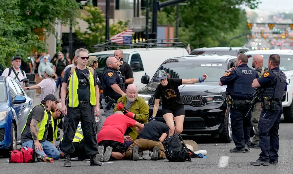 (Francisco Kjolseth | The Salt Lake Tribune) Medical personnel attend to an injured man after a reported shooting during a demonstration in downtown Salt Lake City on Saturday, June 14, 2025.