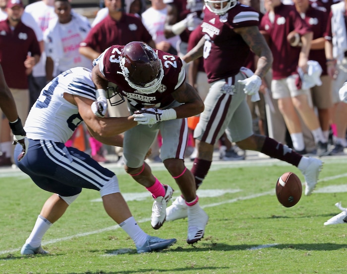 BYU place kicker Andrew Mikkelsen (83) forces Mississippi State wide receiver Keith Mixon (23) to fumble the ball during the second half of an NCAA college football game in Starkville, Miss., Saturday, Oct. 14, 2017. Mississippi State won 35-10. (AP Photo/Jim Lytle)