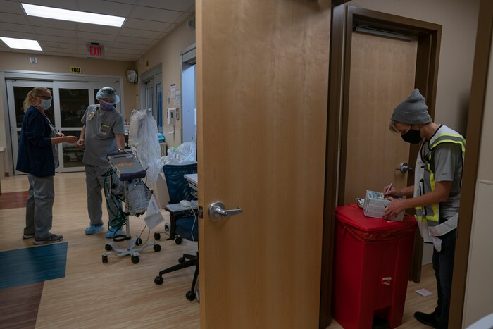 Team Rubicon volunteers, nurse Cindy Robison, a U.S. Air Force veteran from Colorado Springs, Colo., left, and Dennis Grooms, an EMT from St. Louis, center, work with their only ventilator, as Christra McDermont, a U.S. Navy veteran from Los Angeles, and operation section chief, counts face masks in the emergency room of the Kayenta Health Center on the Navajo reservation in Kayenta, Ariz., on April 19, 2020. The reservation has some of the highest rates of coronavirus in the country. Team Rubicon is helping with medical operations as cases of COVID-19 surge. (AP Photo/Carolyn Kaster)