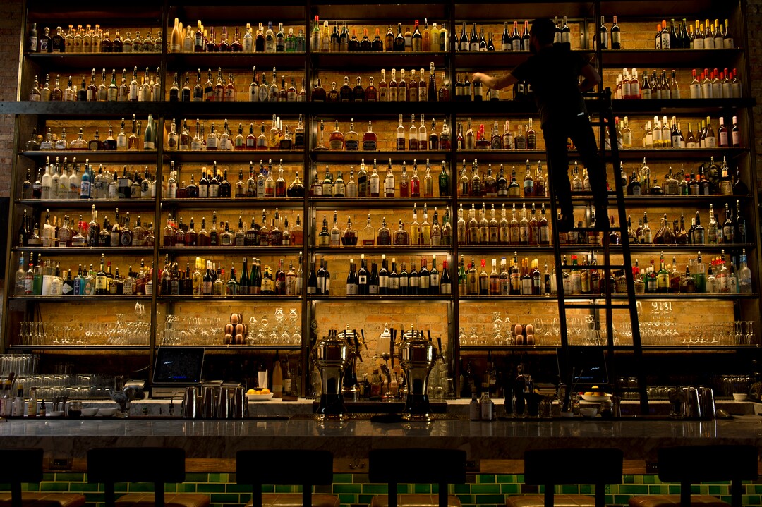 (Leah Hogsten  |  The Salt Lake Tribune) White Horse Spirits and Kitchen bartender Sam Wood restocks the shelves behind the bar.