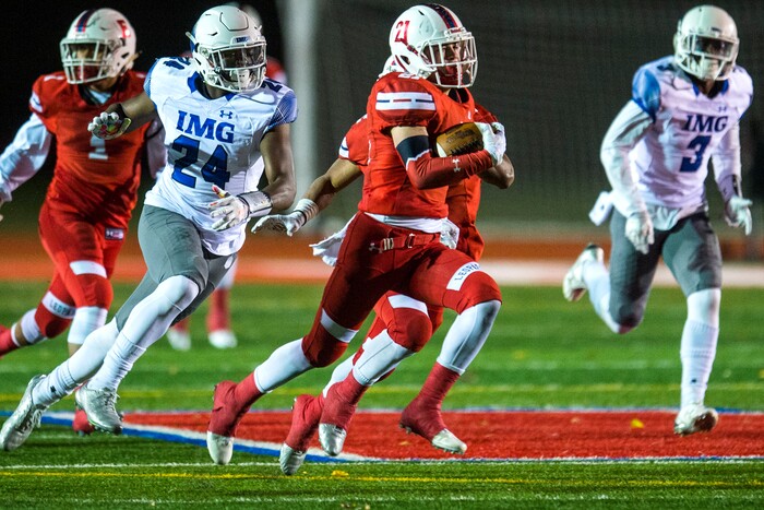 (Chris Detrick  |  The Salt Lake Tribune)  East's Charlie Vincent (21) runs past IMG Academy's Mike Jones (24) and IMG Academy's Houston Griffith (3) during the game at East High School Friday, October 20, 2017. 