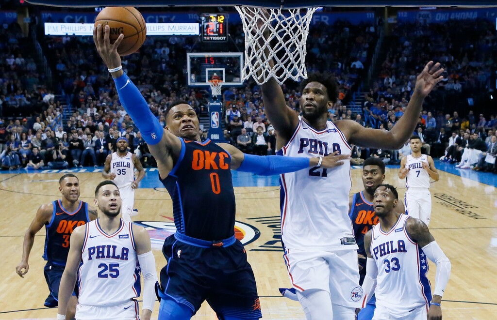 Oklahoma City Thunder guard Russell Westbrook (0) shoots in front of Philadelphia 76ers center Joel Embiid (21) in the first half of an NBA basketball game in Oklahoma City, Sunday, Jan. 28, 2018. (AP Photo/Sue Ogrocki)