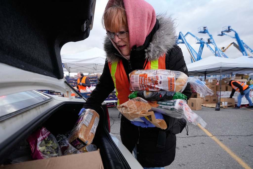 (Francisco Kjolseth | The Salt Lake Tribune) Volunteer Charlie Felgar loads bread into the trunk of a car for the Utah Food for Families distribution at Calvary Salt Lake in Murray on Thursday, March 6, 2025. It's a "frightening" time for food banks across the state, where pandemic demand never died down and now inflation, the threat of tariffs and impending federal layoffs have exacerbated the situation.