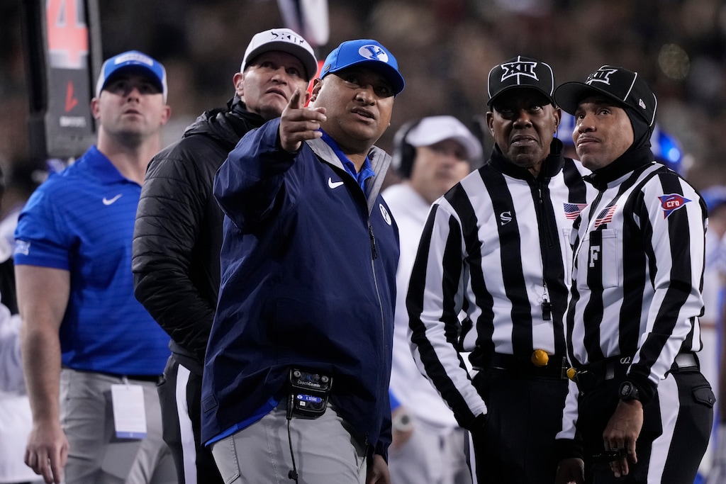 (Carolyn Kaster | AP)  BYU head coach Kalani Sitake, center, looks to a replay with officials during the first half of Saturday's game in Cincinnati.
