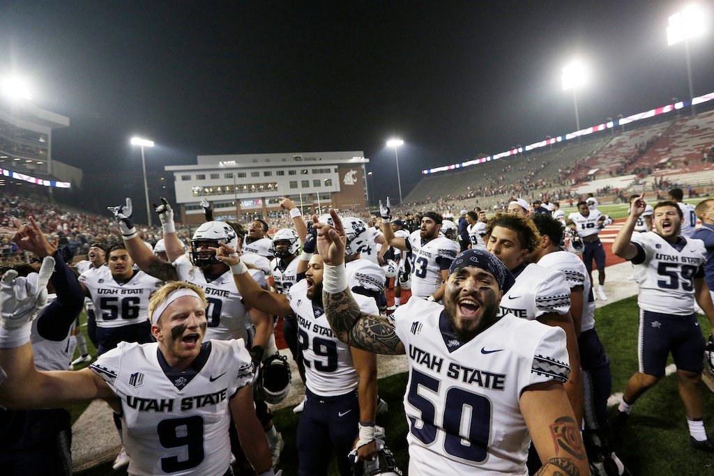 (Young Kwak | AP) Utah State players sing the school's song while celebrating with fans after winning 26-23 against Washington State in an NCAA college football game, Saturday, Sept. 4, 2021, in Pullman, Wash.