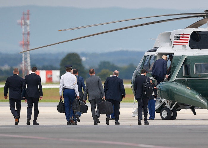 President Donald Trump, right, boards Marine One helicopter, followed by members of his staff at Hagerstown Regional Airport in Hagerstown, Md., Friday, Aug. 18, 2017, en route to nearby Camp David, for a meeting with his national security team to discuss strategy for South Asia, including India, Pakistan and the way forward in Afghanistan. (AP Photo/Pablo Martinez Monsivais)