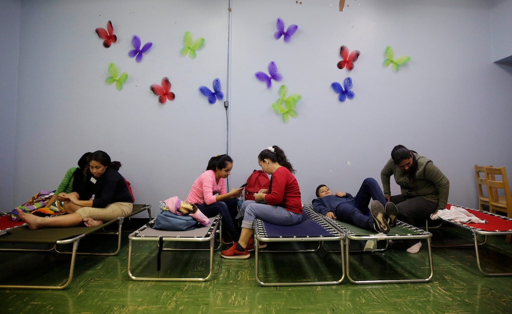 (AP Photo/Eric Gay) Immigrants from Honduras seeking asylum rest on a cot at Travis Park Church which is serving as a make-shift shelter, Tuesday, April 2, 2019, in downtown San Antonio. The surge of migrants arriving at the southern border has led the Trump administration to dramatically expand a practice it has long mocked as "catch and release."