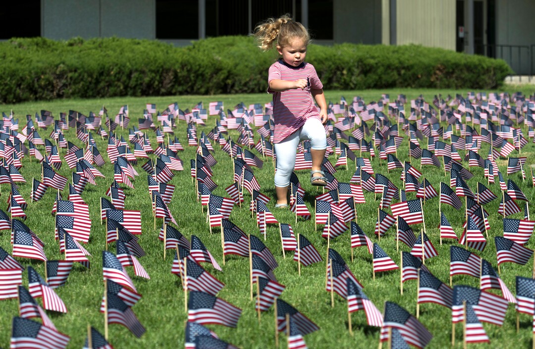 (Rick Egan  |  The Salt Lake Tribune)   Lillian Edwards, 2 1/2, from Millcreek, walks through the 3000 flags in front of Skyline High School in memory of those who lost their lives 17 years ago.  Tuesday, Sept. 11, 2018.