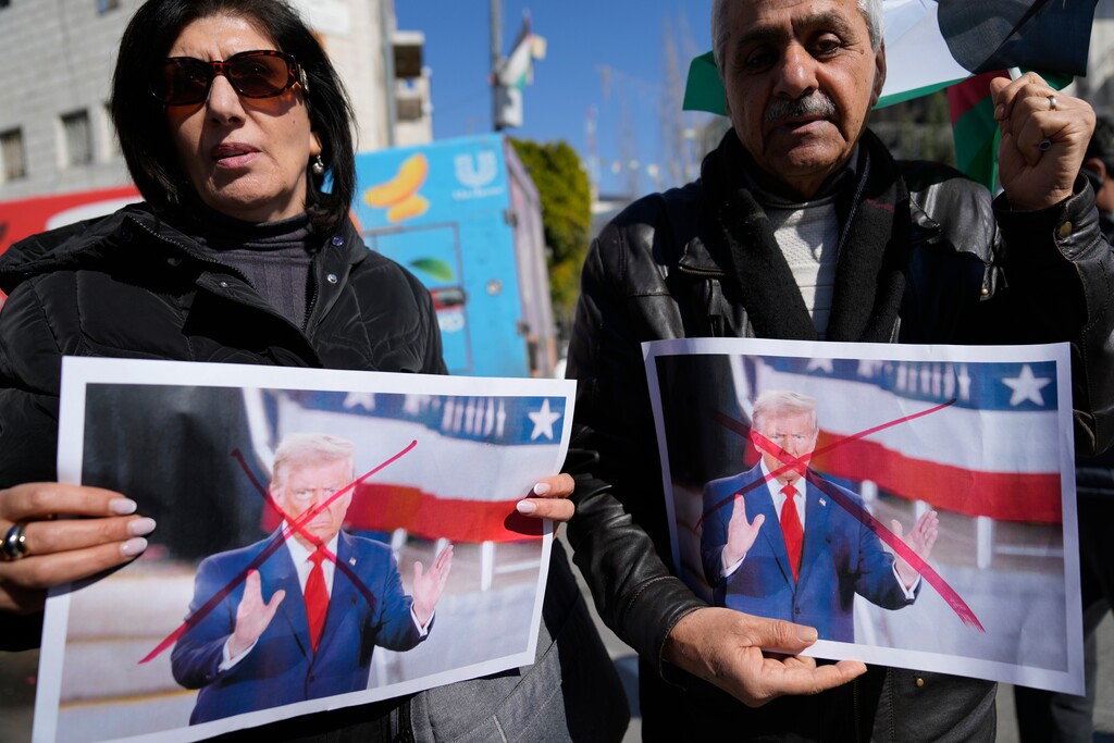(Nasser Nasser | AP) Palestinians carry defaced pictures of U.S. President Donald Trump while protesting against his latest statements regarding the transfer of Palestinians from Gaza, in the West Bank city of Ramallah Wednesday, Jan. 29, 2025.
