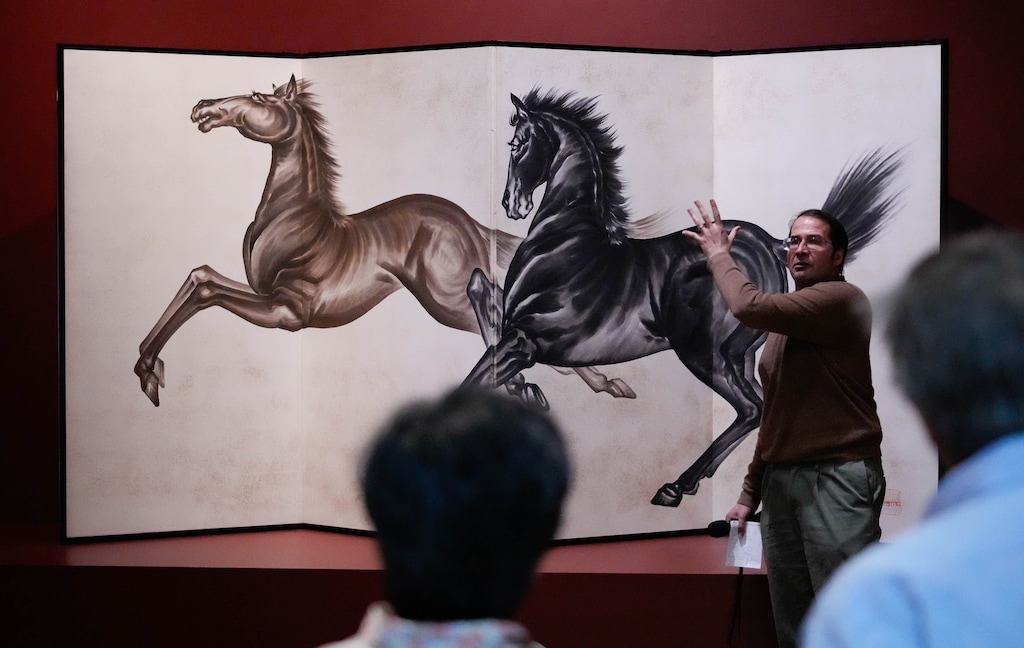 (Francisco Kjolseth  |  The Salt Lake Tribune) Luke Kelly, associate director of collections at the Utah Museum of Fine Arts, talks about the 1923 four-panel screen "Two Running Horses" by artist Chiura Obata, during an event at the museum on Friday, May 3, 2024. Some 80 visitors on a pilgrimage to the Topaz War Relocation Center in Delta stopped at the Salt Lake City museum, where an exhibition, "Pictures of Belonging," is featuring works by three Japanese American women artists — two of whom were incarcerated at Topaz during World War II.