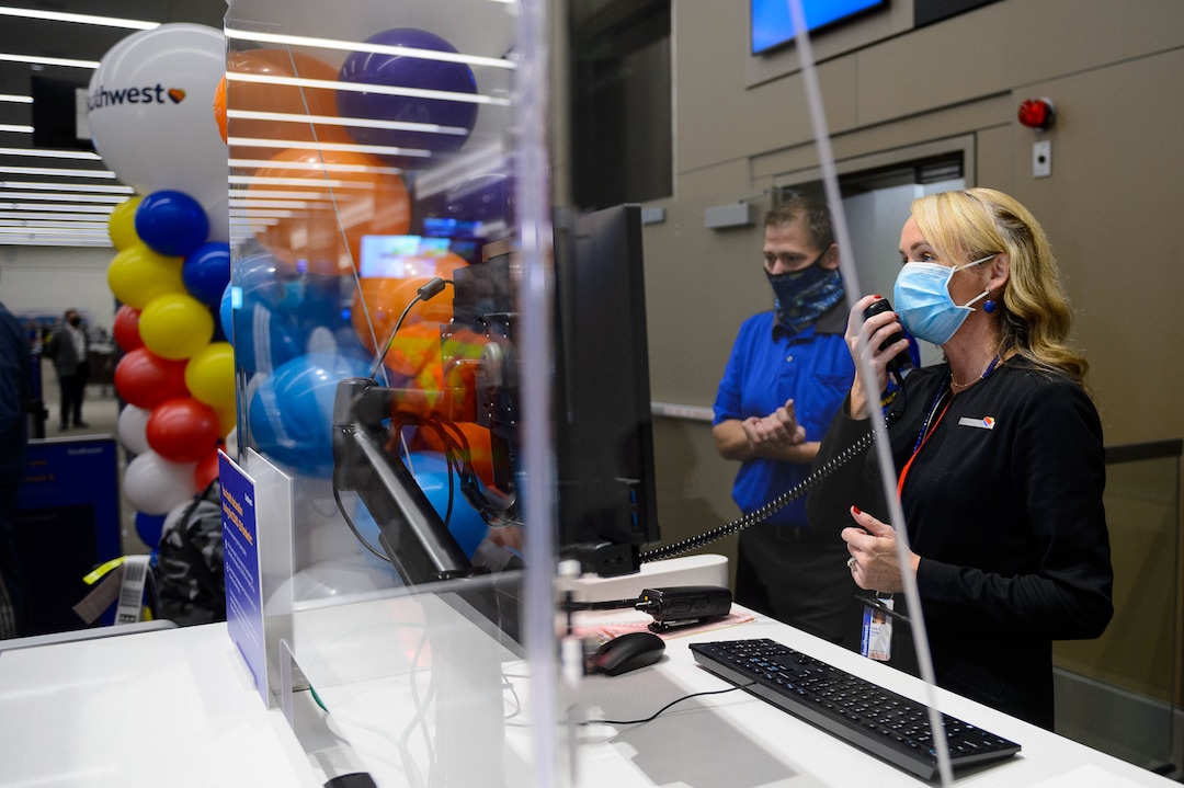 (Trent Nelson  |  The Salt Lake Tribune) Southwest Airlines' Holly Davies works the gate from behind a plexiglass shield for the first flight out of concourse B at the Salt Lake City International Airport on Tuesday, Oct. 27, 2020.