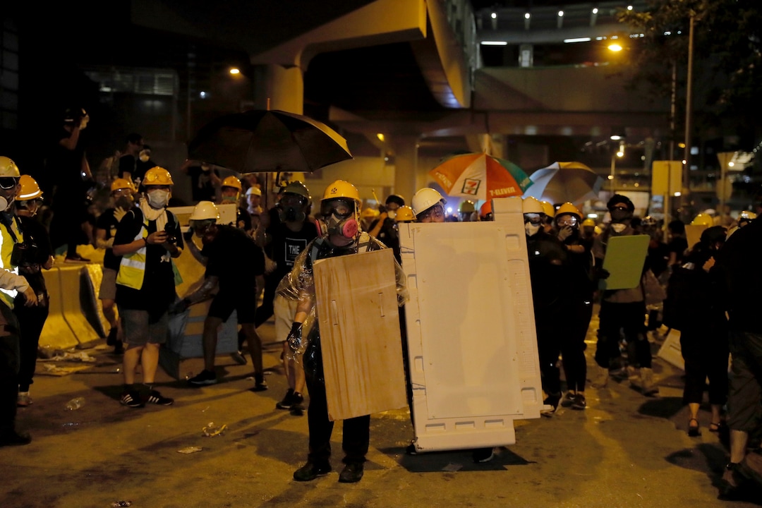 (Kin Cheung | AP Photo) Protesters prepare to defend against police action at the Legislative Council in Hong Kong, during the early hours of Tuesday, July 2, 2019. Protesters in Hong Kong took over the legislature's main building Friday night, tearing down portraits of legislative leaders and spray painting pro-democracy slogans on the walls of the main chamber.