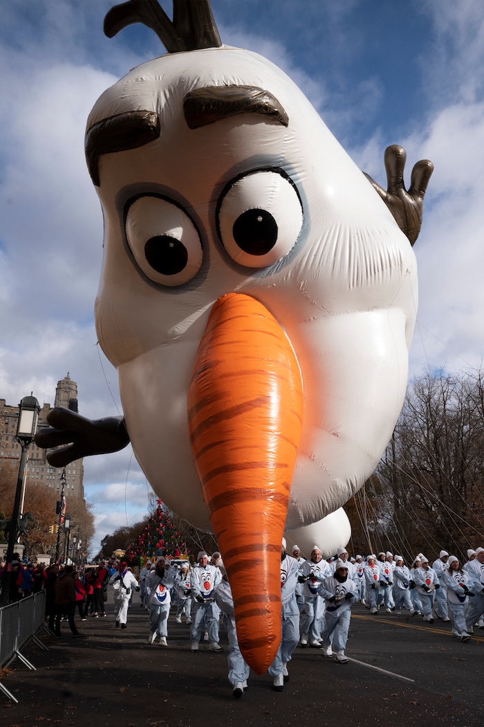 (Mark Lennihan | AP) Balloon handlers hold the Olaf balloon as his nose dips toward the ground as strong winds affect the Macy's Thanksgiving Day Parade, Thursday, Nov. 28, 2019, in New York.