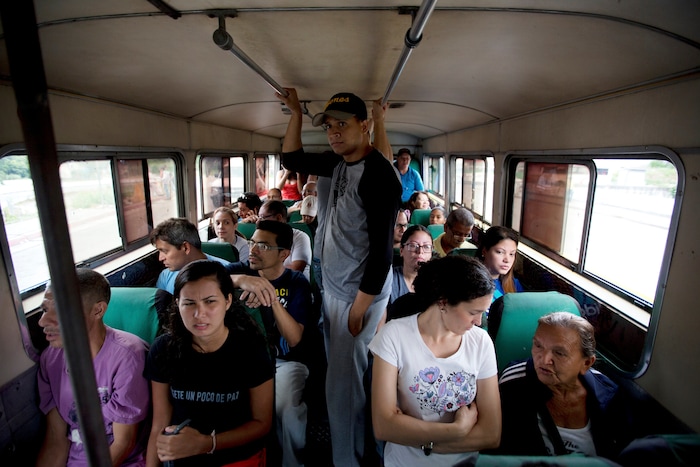 Voters ride a bus arranged by the opposition that transports voters to new polling stations during regional elections in Caracas, Venezuela, Sunday, Oct. 15, 2017. Elections could tilt a majority of the states' 23 governorships back into opposition control for the first time in nearly two decades of socialist party rule, though the government says the newly elected governors will be subordinate to a pro-government assembly. (AP Photo/Fernando Llano)