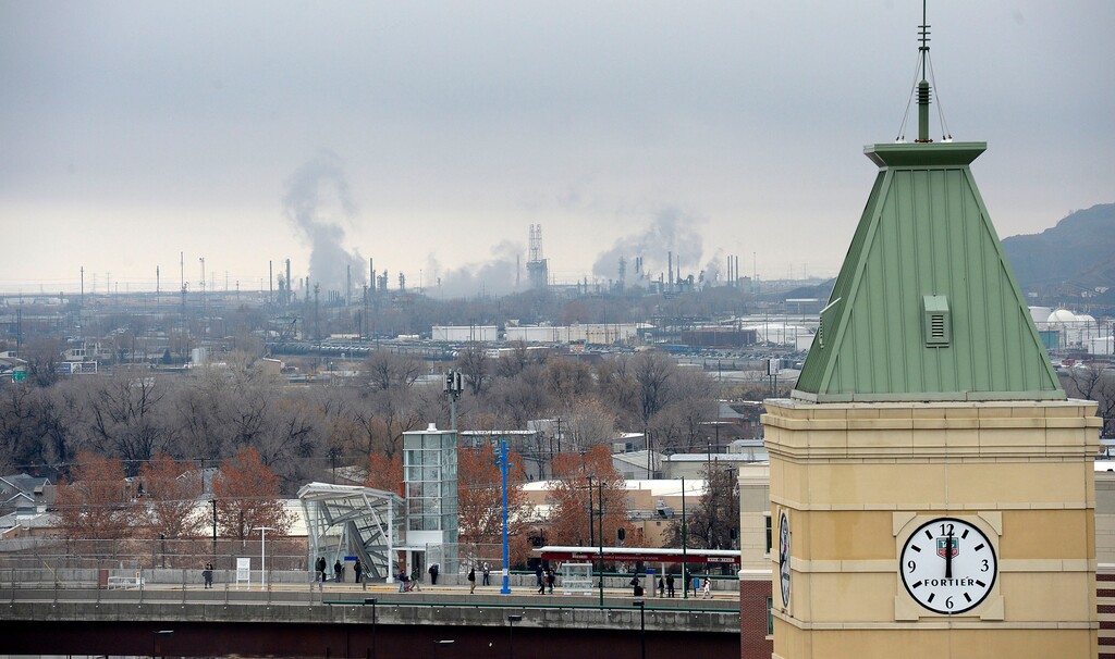 (Al Hartmann  |  The Salt Lake Tribune) View of tower at Gateway in foreground, Trax station mid-frame with emissions of oil refineries in North Salt Lake behind. Welcome to January weather limbo. Alternating days of storms blow polluted air out of the Salt Lake valley followed by a build up of stagnant air that allow pm 2.5 to build up again.