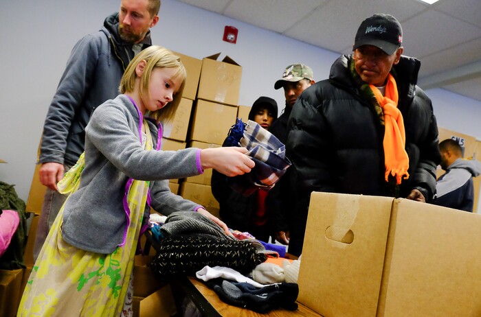 (Francisco Kjolseth | The Salt Lake Tribune) Brad Wade and his daughter Reese, 9, hand out hats and gloves to the homeless and those in need at the Salt Lake City Mission at 1055 North Redwood Road in Salt Lake City, before a Thanksgiving banquet on Thursday, Nov. 28, 2019.