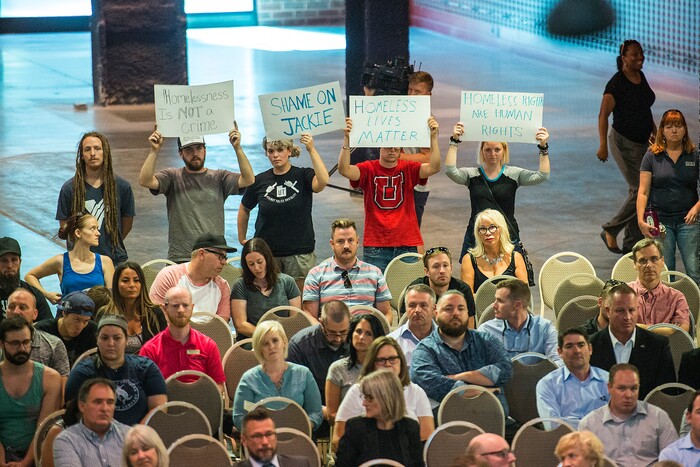 (Chris Detrick  |  The Salt Lake Tribune)  Nick Godfrey, Jade Arter, Christian Hartshorn and Kate Wilhite hold up signs as Salt Lake City Mayor Jackie Biskupski speaks during a public forum about Operation Rio Grande at The Gateway in Salt Lake City Tuesday, August 15, 2017. 