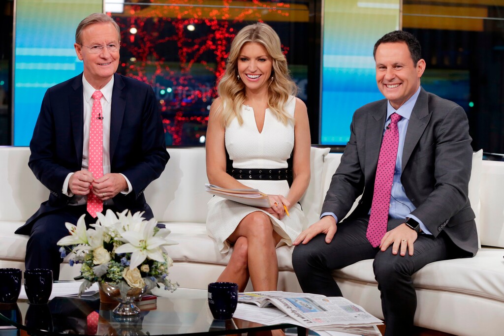 FILE - In this Jan. 17, 2018 file photo, "Fox & Friends" co-hosts, from left, Steve Doocy, Ainsley Earhardt and Brian Kilmeade appear on their set in New York. Roughly 1.5 million people watch "Fox & Friends" each day, more than its counterparts at CNN and MSNBC and less than half the audiences for "Good Morning America" or "Today." (AP Photo/Richard Drew, File)