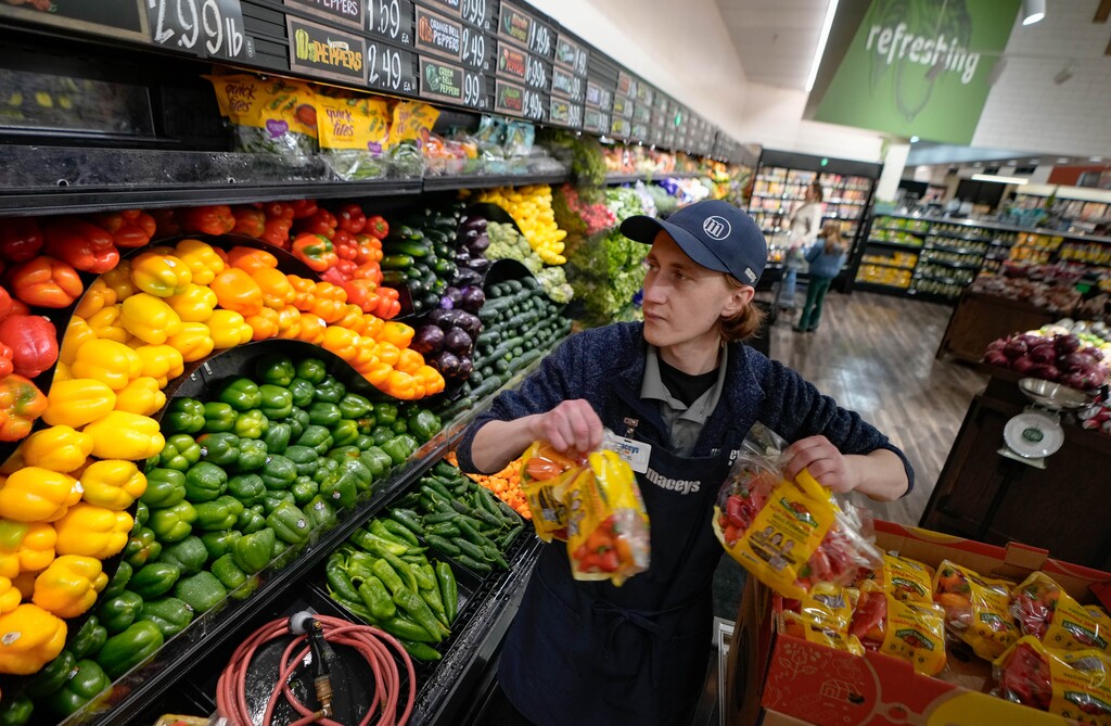 (Francisco Kjolseth  |  The Salt Lake Tribune) Michael Johnson, assistant produce manager at the recently renovated Macey’s Market in Sugar House, stocks fresh produce on Tuesday, March 6, 2024. Groceries are among the items that have become more expensive amid inflation, and many Utahns are worried about rising costs.