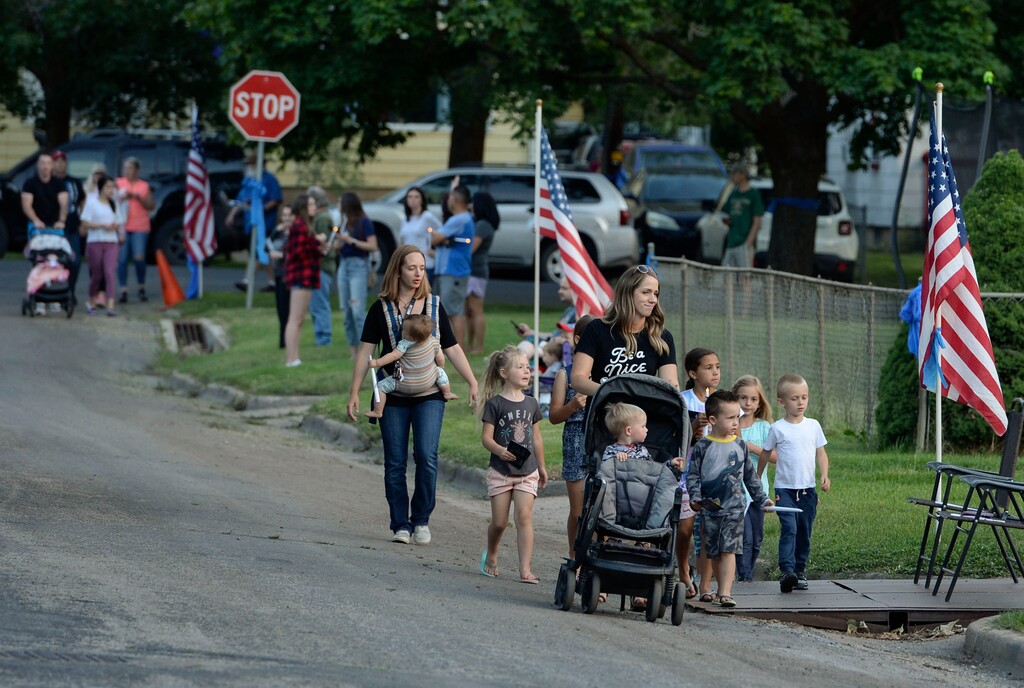 (Leah Hogsten  |  Tribune file photos) Friends and supporters lined the neighborhood of Officer Nate Lyday's childhood home on Custer Avenue in Ogden prior to the Memorial Procession and Community Vigil in honor of Lyday's life. The procession made its way through five other Ogden landmarks before ending at Lindquist Field.